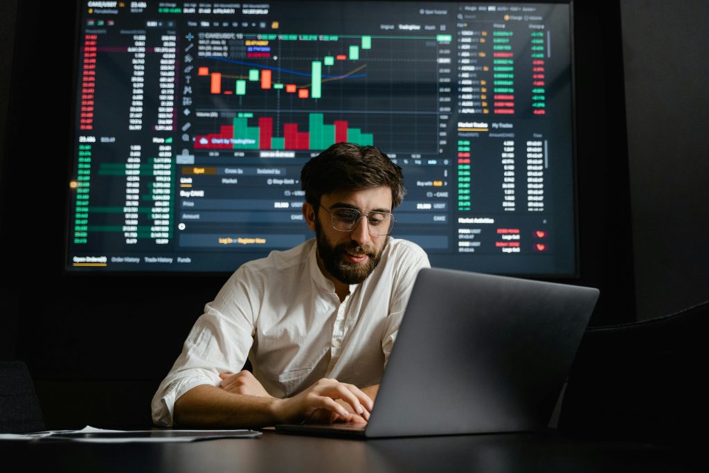 Home Male analyst studies cryptocurrency trends at a workstation with multiple displays showing market data.