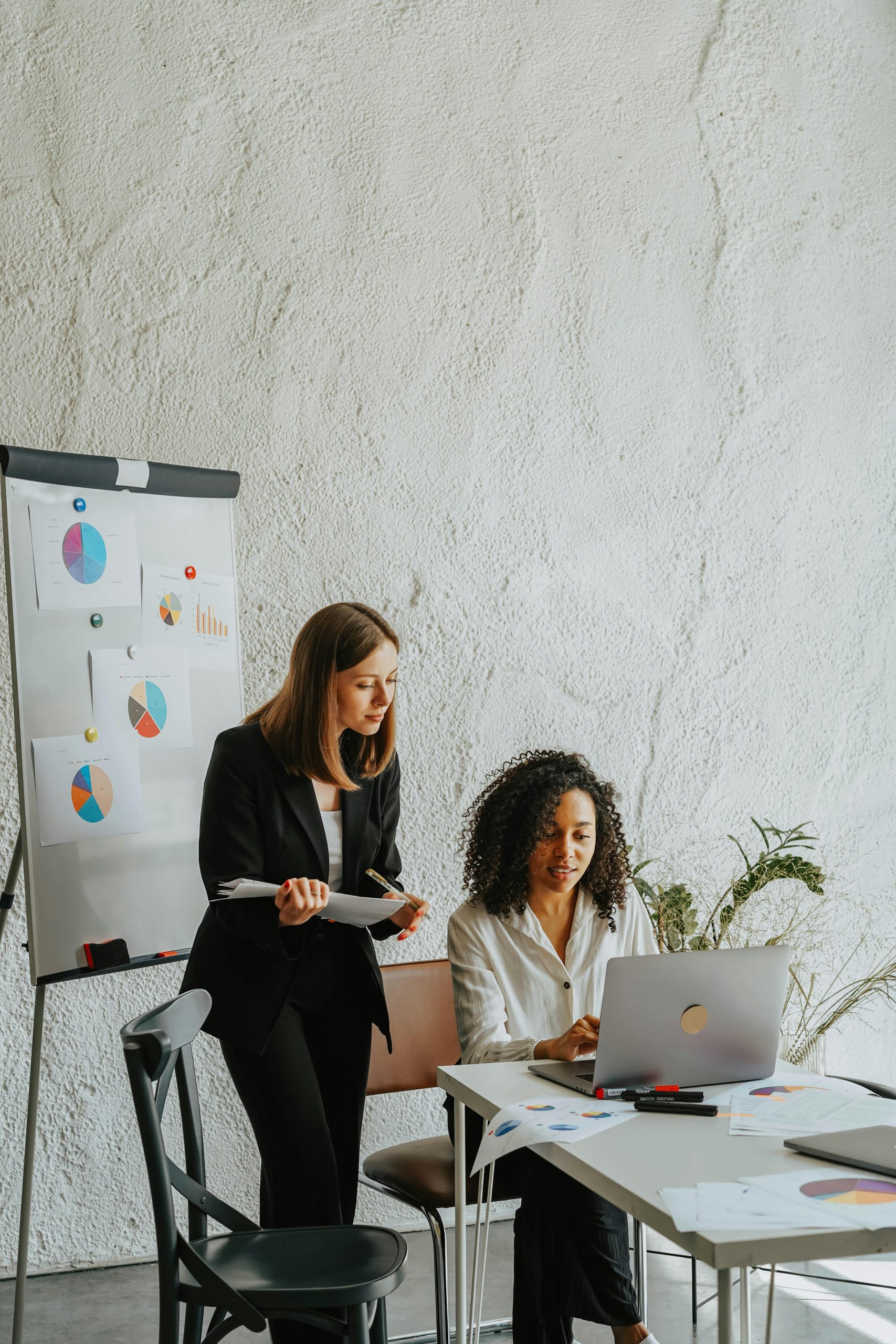 • Search Engine Marketing (SEM) Two businesswomen analyzing graphs on a whiteboard during a meeting.